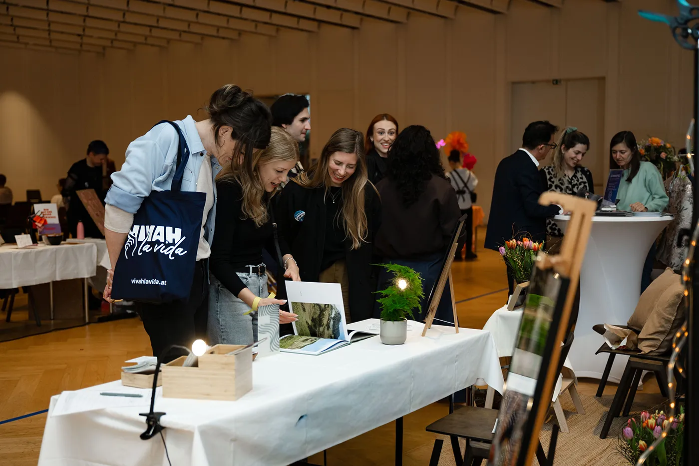 Besucher:innen betrachten die Auslage an einem Messestand