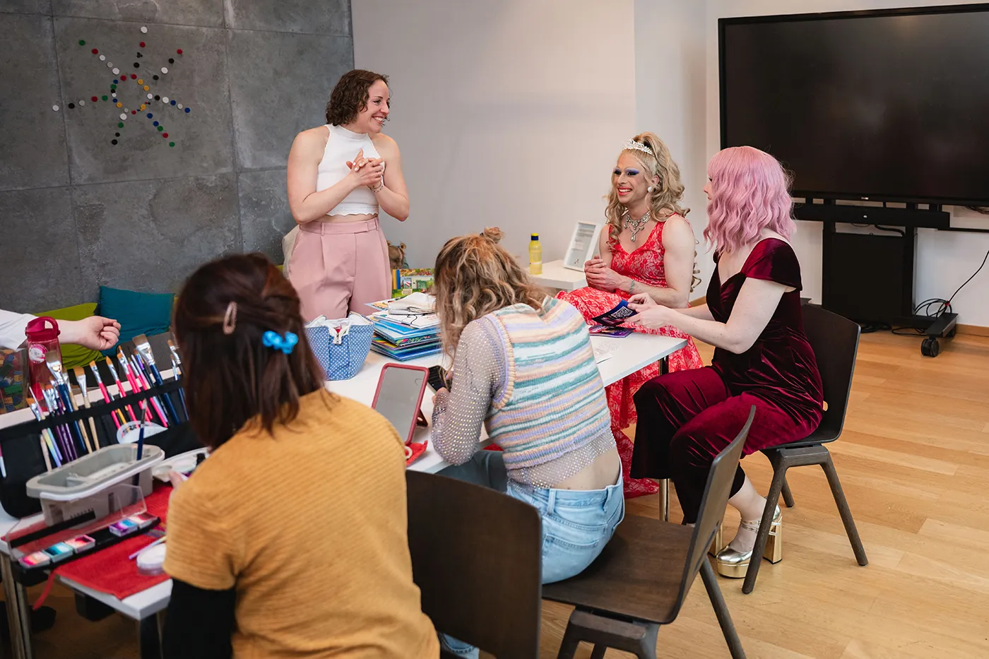 Drag Artists basteln mit Kindern am Tisch bei der Kinderlesung