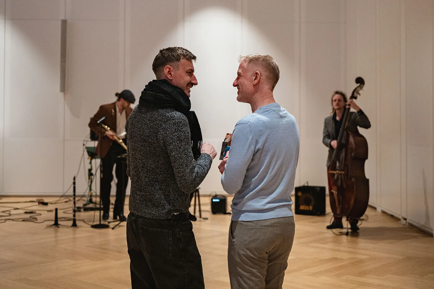 Zwei Besucher im Gespräch, im Hintergrund spielt die Live-Band
