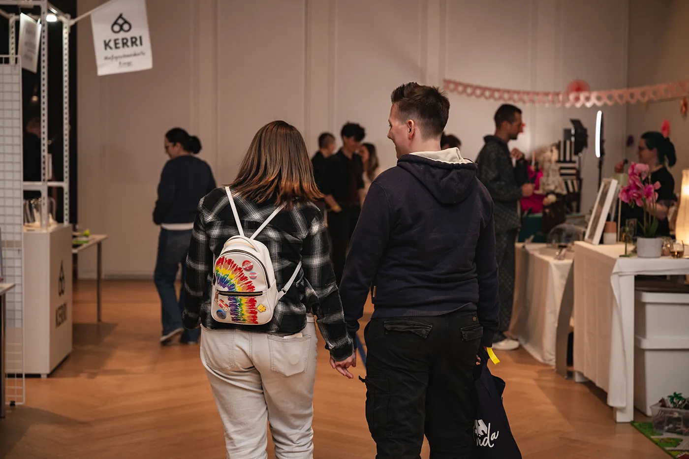 Paar geht Hand in Hand durch die Messehalle