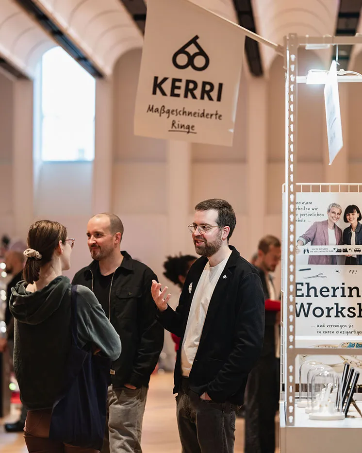 Gespräch über maßgeschneiderte Eheringe am Stand von KERRI