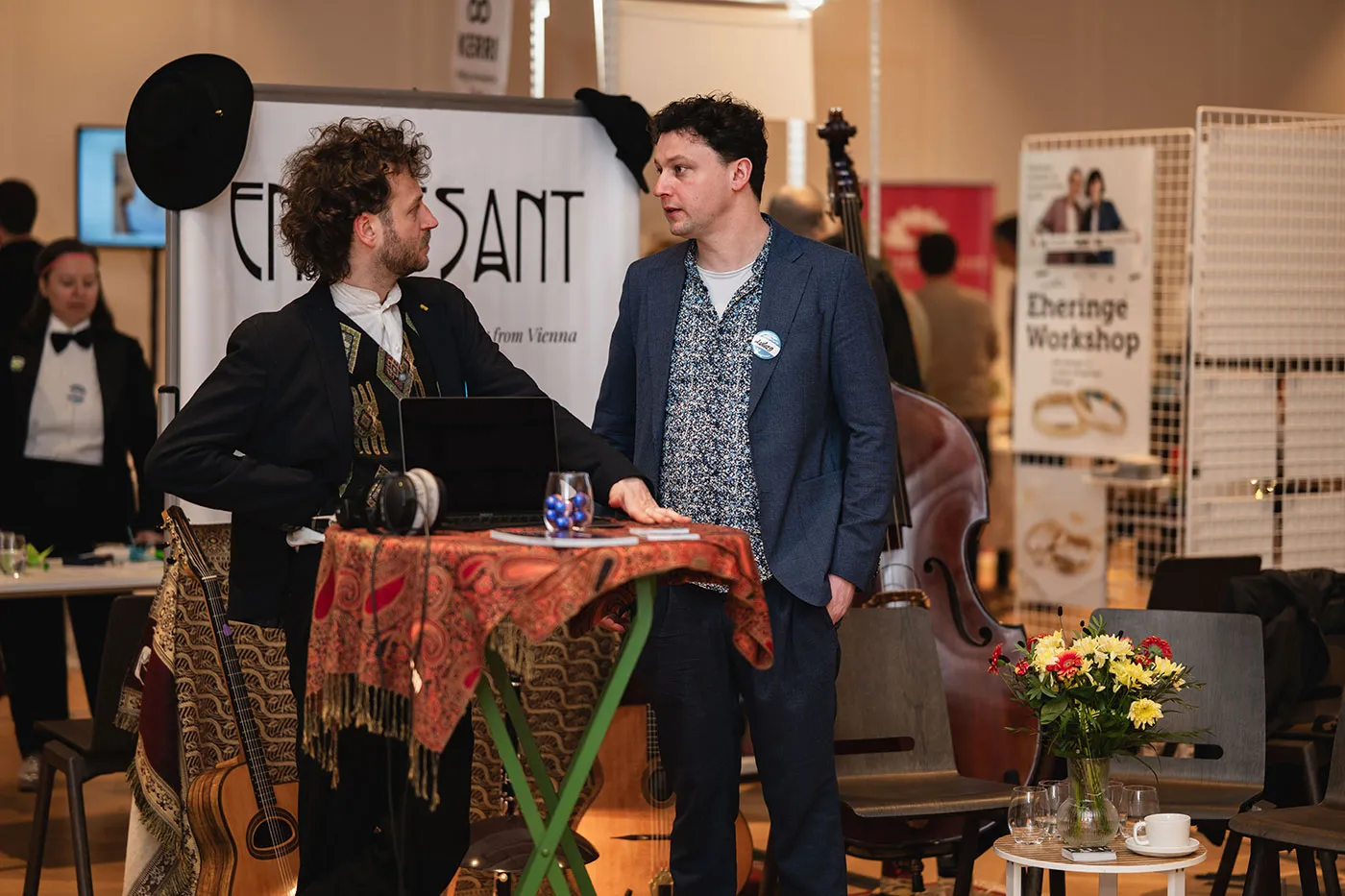 Gespräch am Stand von En Passant, im Hintergrund ein Kontrabass