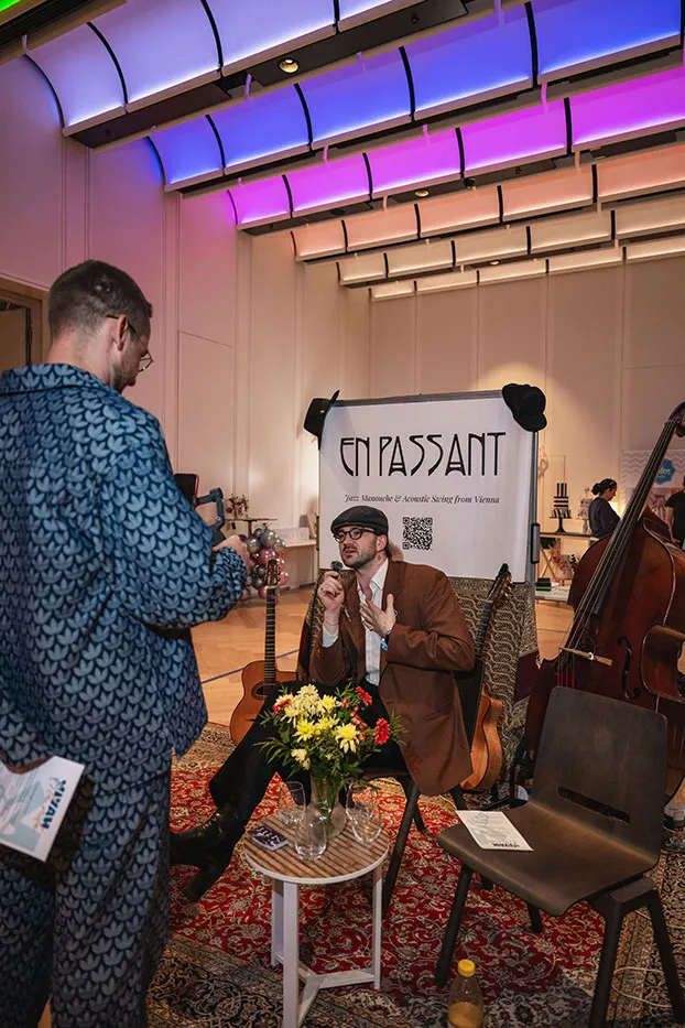 Musiker von En Passant singt am Stand, daneben Gitarre und Kontrabass