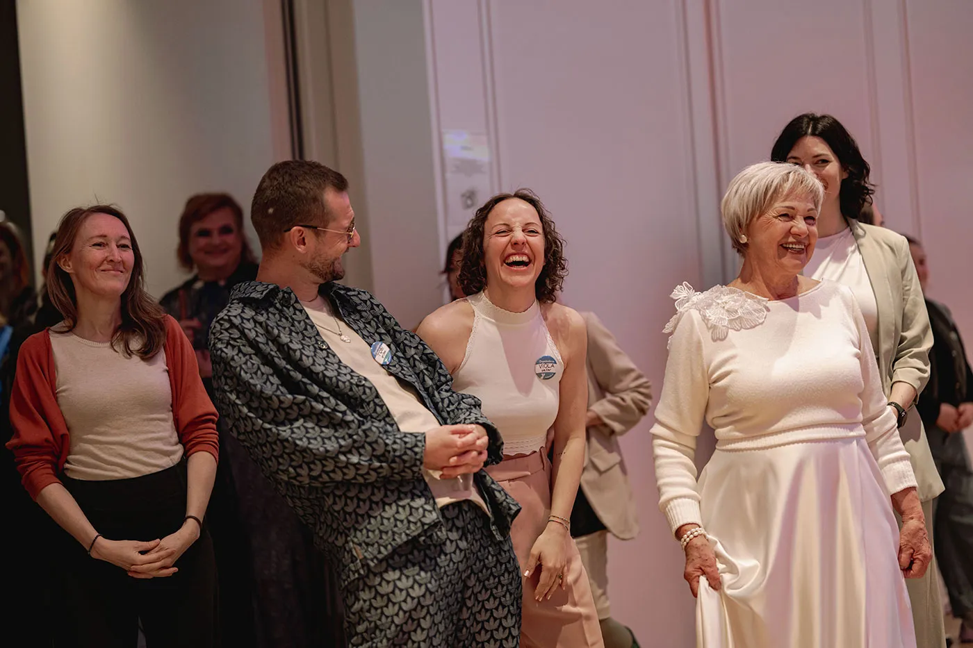 Gäste lachen gemeinsam bei der Hochzeitsmesse